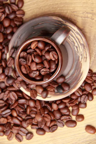 Deliziosi chicchi di caffè marrone scuro in tazza di caffè in ceramica — Foto Stock