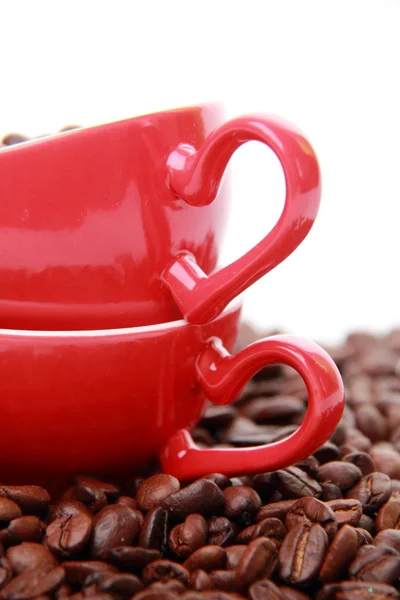 Granos de café en taza de café rojo con símbolo del corazón —  Fotos de Stock