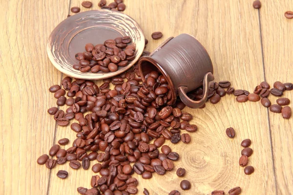 Deliziosi chicchi di caffè marrone scuro in piccola tazza di caffè in ceramica — Foto Stock
