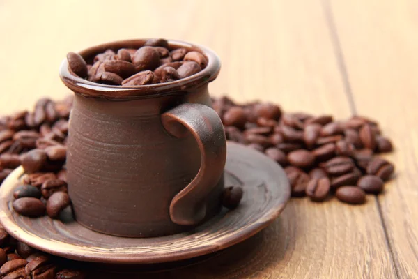 Délicieux grains de café brun foncé dans une petite tasse de café en céramique — Photo