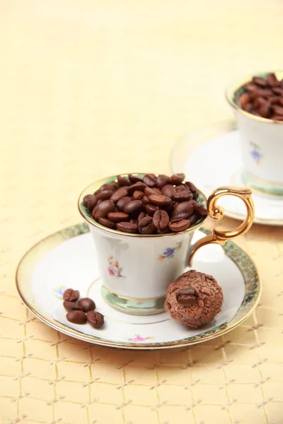 Two beautiful coffee cups with coffee beans and dessert — Stock Photo, Image