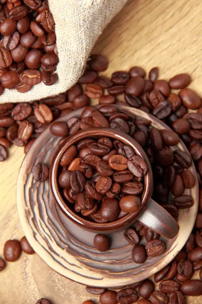 Chicchi di caffè marrone scuro con tazza di caffè in ceramica — Foto Stock