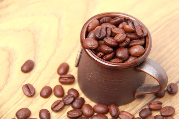 Deliziosi chicchi di caffè marrone scuro in tazza di ceramica — Foto Stock