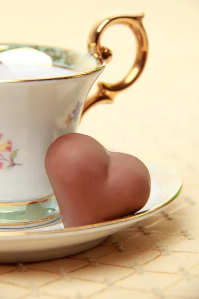 Classic coffee cup and chocolate candy on the tablecloth