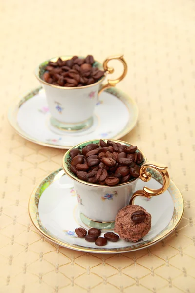 Two beautiful coffee cups with coffee beans and dessert — Stock Photo, Image