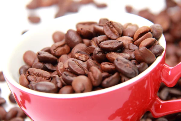 Vista superior em grãos de café em copo vermelho — Fotografia de Stock