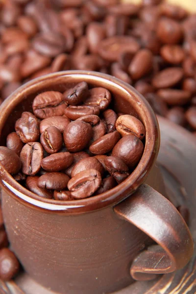 Deliziosi chicchi di caffè in tazza di ceramica — Foto Stock