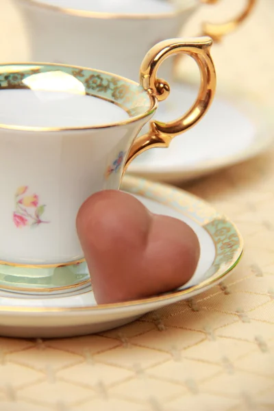 Classic coffee cups and chocolate candy on the tablecloth — Stock Photo, Image