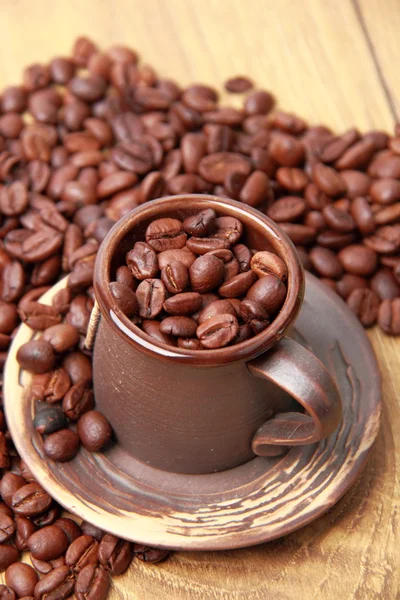 Deliziosi chicchi di caffè marrone scuro in piccola tazza di ceramica — Foto Stock