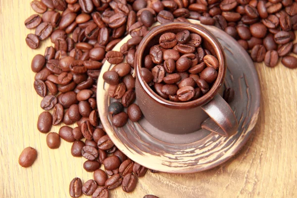 Deliciosos granos de café marrón oscuro en taza de cerámica — Foto de Stock
