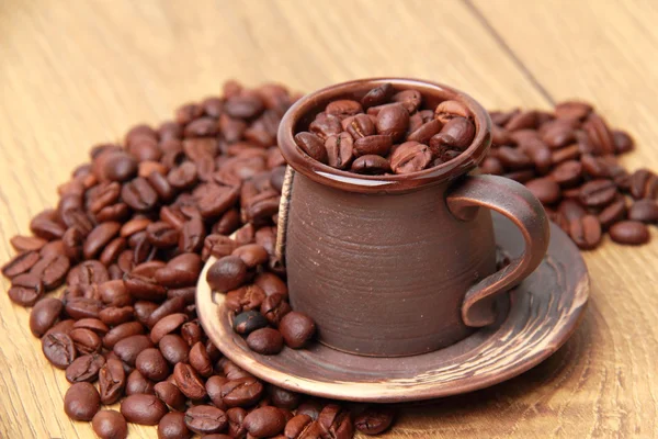 Delicious dark brown coffee beans in small ceramic coffee cup Royalty Free Stock Photos