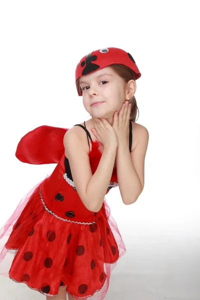 Glad liten flicka klädd i röd kostym med vingar nyckelpiga — Stockfoto
