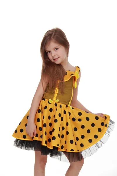 Charming emotional little girl in a yellow dress — Stock Photo, Image