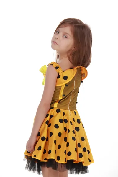 Charming emotional little girl in a yellow dress — Stock Photo, Image