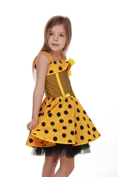 Charming emotional little girl in a yellow dress — Stock Photo, Image