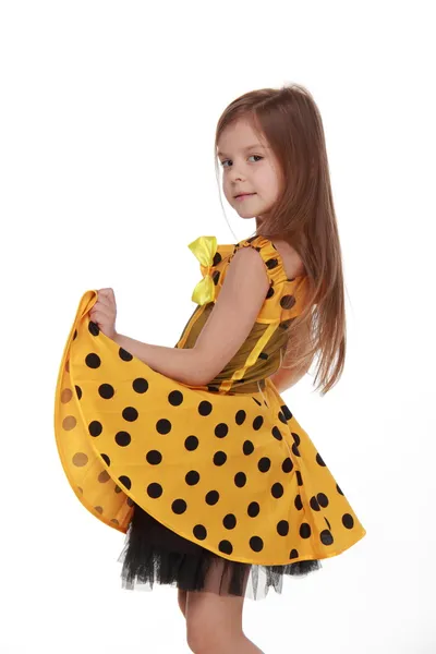 Charming emotional little girl in a yellow dress — Stock Photo, Image