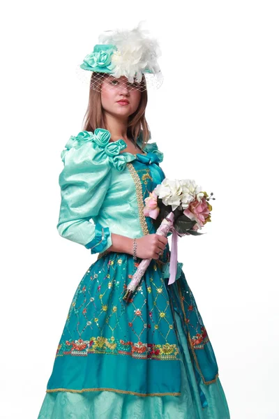 Vrouw in een mooie jurk en een charmante hoed met bloemen — Stockfoto