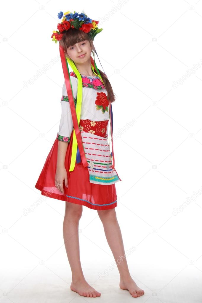 Girl in flowers wreath and traditional clothes