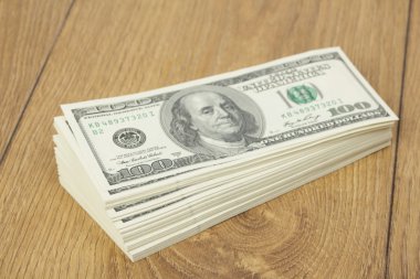 yüz dolarlık banknotlar ahşap zemin üzerine yığını