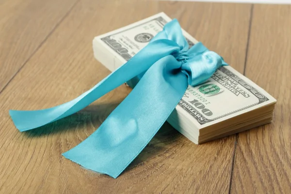Paquete regalo de 100 dólares con cinta azul — Foto de Stock