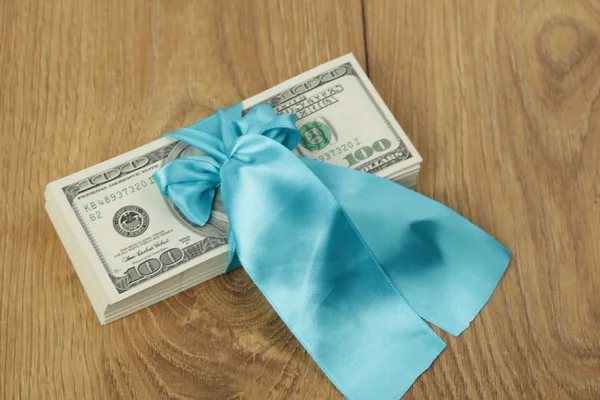 100 dolarów gift pack z niebieską wstążką — Zdjęcie stockowe