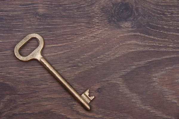 Chiave antica isolata su fondo di legno scuro — Foto Stock