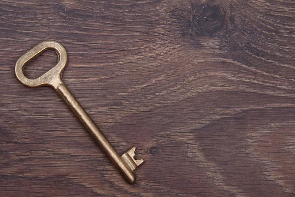 Античний ключ ізольований на темному дерев'яному фоні — стокове фото