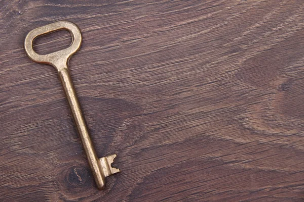 Llave antigua aislada sobre fondo de madera oscura —  Fotos de Stock