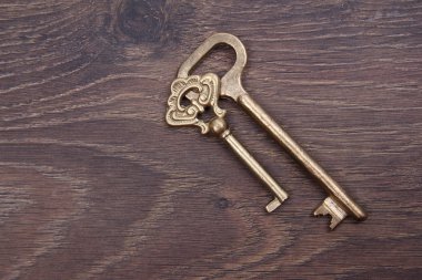 koyu ahşap zemin üzerinde süsleme ile iki eski anahtar