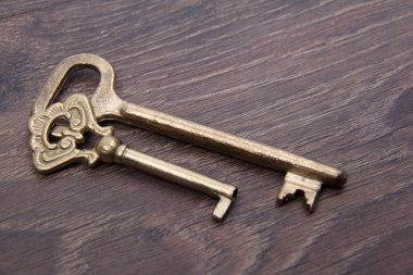 koyu ahşap zemin üzerinde süsleme ile iki eski anahtar