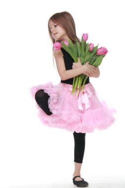 Lale güzel bir buket tutarak uzun saçlı sevimli küçük dansçı