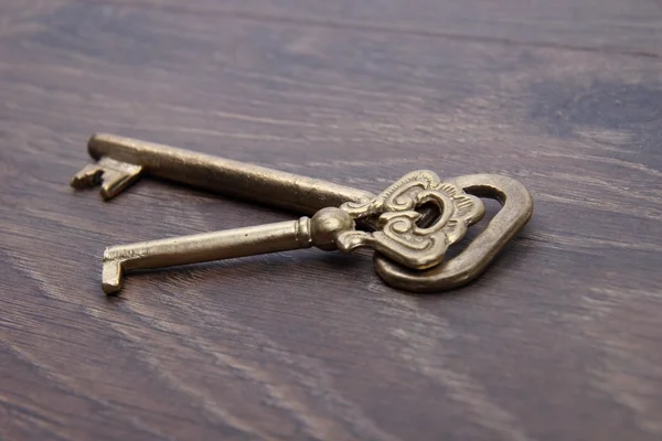 Dos llaves antiguas con adorno sobre fondo de madera oscura —  Fotos de Stock