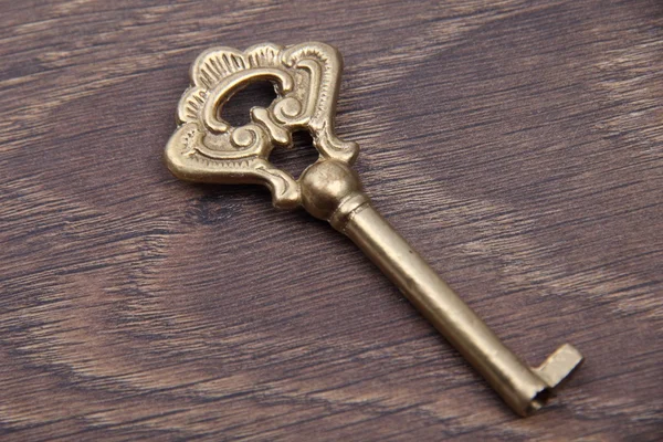 Древний ключ с орнаментом на темном деревянном фоне — стоковое фото