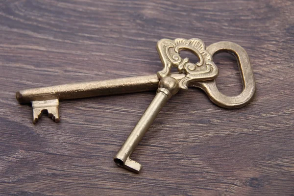 Duas chaves antigas com ornamento no fundo de madeira escura — Fotografia de Stock