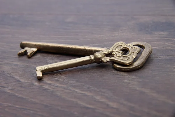 Dos llaves antiguas con adorno sobre fondo de madera oscura — Foto de Stock