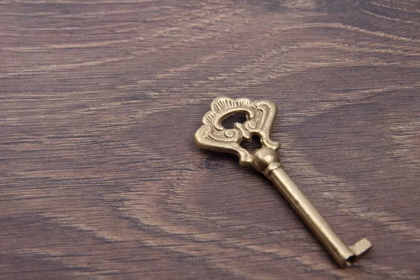 Παλιό κλειδί με στολίδι σε σκούρο φόντο ξύλινη — Φωτογραφία Αρχείου