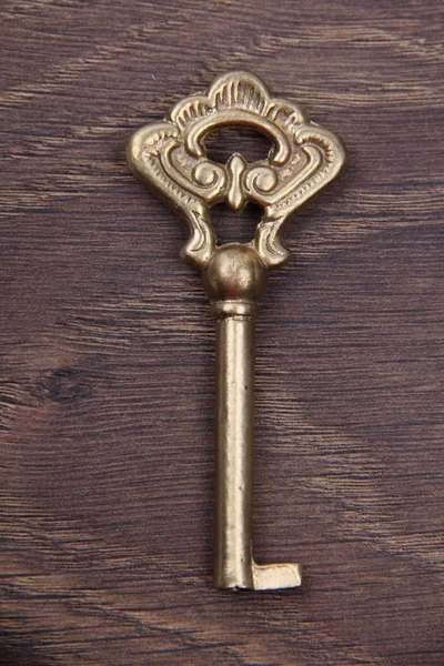 Oude sleutel met sieraad op donkere houten achtergrond — Stockfoto