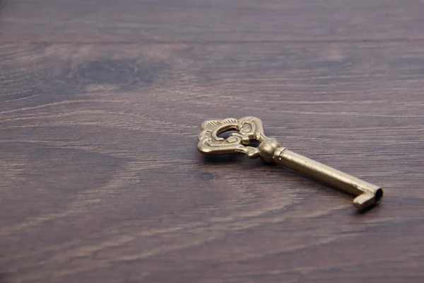 Koyu ahşap zemin üzerinde süsleme ile eski anahtar — Stok fotoğraf