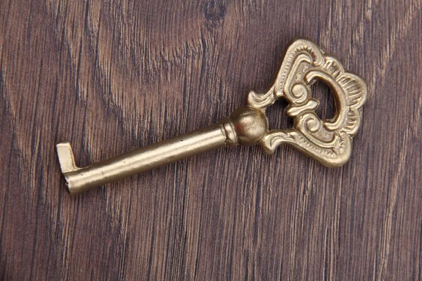 Stary klucz z ornamentem na ciemnym tle drewniane — Zdjęcie stockowe