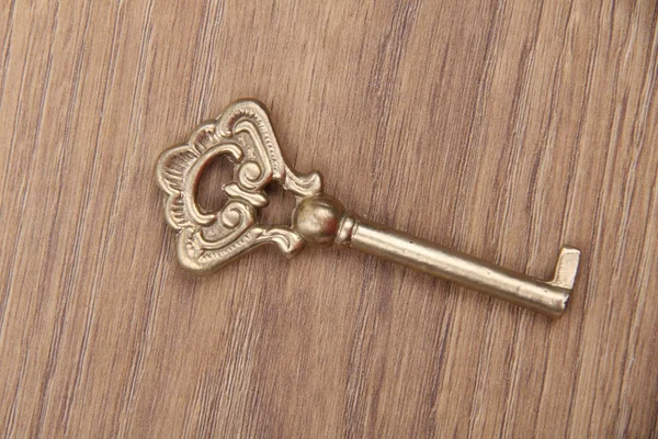 Древний ключ с орнаментом на деревянном фоне — стоковое фото