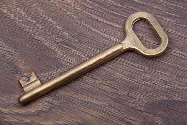 Antique key isolated on dark wooden background