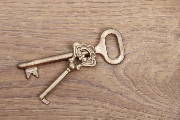 Dva staré klíče s ornament na dřevěné pozadí — Stock fotografie