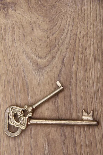 Twee oude sleutels met sieraad op houten achtergrond — Stockfoto