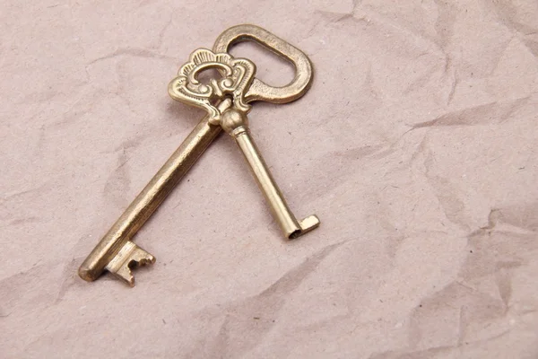 Dos llaves antiguas con adorno sobre un fondo de papel arrugado — Foto de Stock