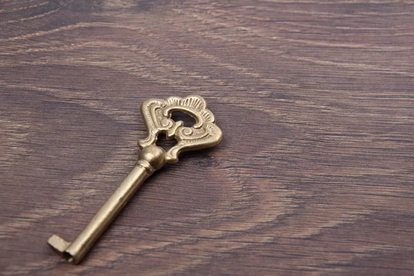 Antieke sleutel met sieraad op donkere houten achtergrond — Stockfoto