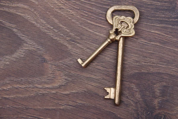 Dos llaves antiguas con adorno sobre fondo de madera — Foto de Stock