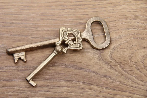 Due vecchie chiavi con ornamento su sfondo di legno — Foto Stock