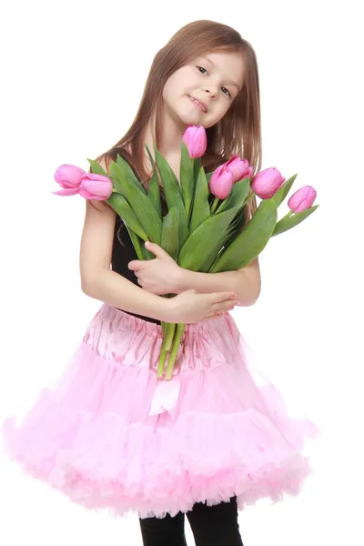 Fröhliches kleines Mädchen im Tutu mit einem großen Strauß Tulpen — Stockfoto