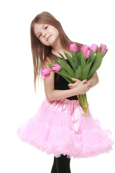 Schattige kleine danser met lange haren die een mooi boeket van tulpen — Stockfoto