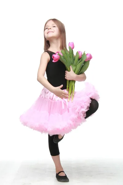 Baletka v tutu s kyticí tulipánů je v baletní pozice — Stock fotografie